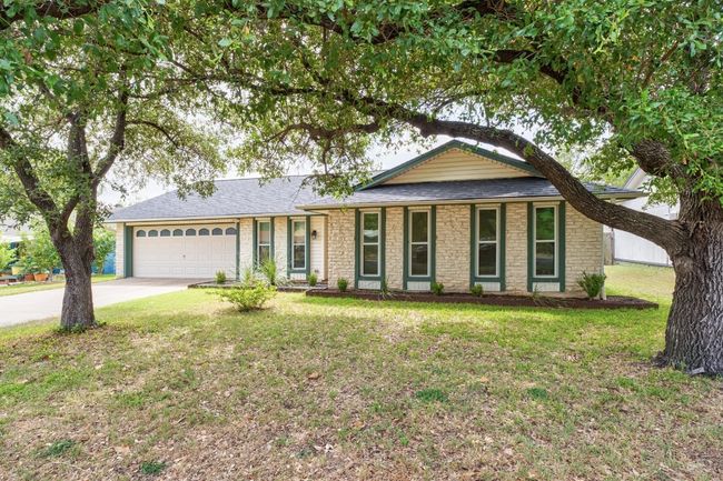Ranch-style house featuring an attached garage, driveway, stone siding, and a front yard | Image 29