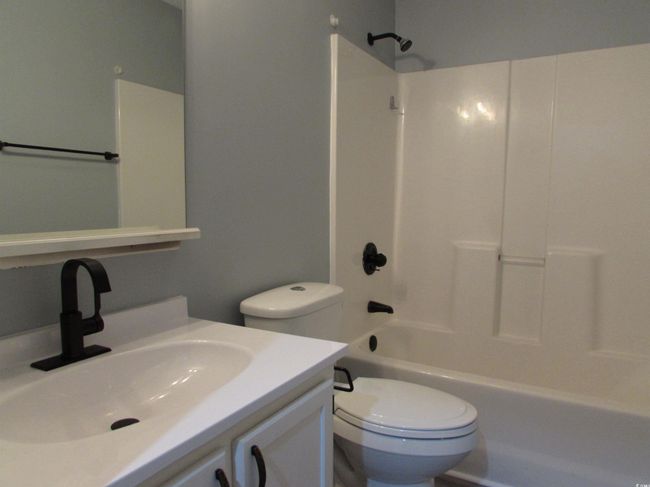 Full bath with toilet, vanity, and a tub / shower combination. | Image 17