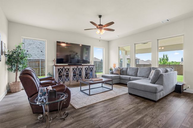 Living area with wood finished floors, ceiling fan, and plenty of natural light | Image 6
