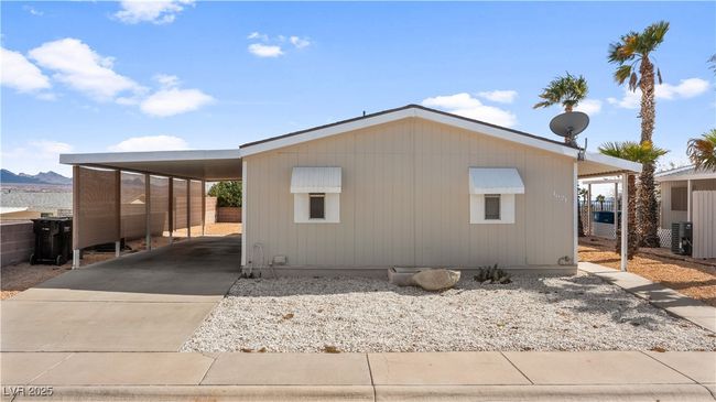 View of home's exterior with driveway, an attached carport, and fence | Image 59