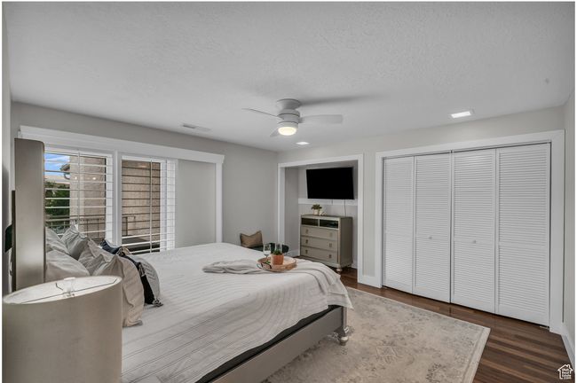 Bedroom featuring wood finished floors, a textured ceiling, and ceiling fan | Image 18
