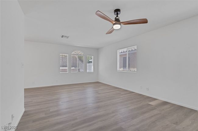 Spare room with a ceiling fan and wood finished floors | Image 5