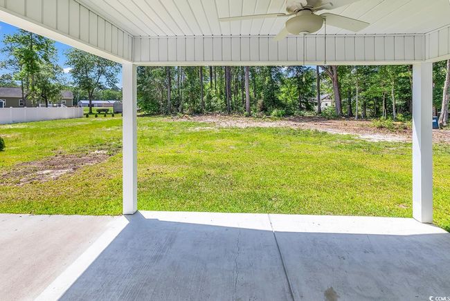 View of grassy yard with ceiling fan and a patio | Image 32