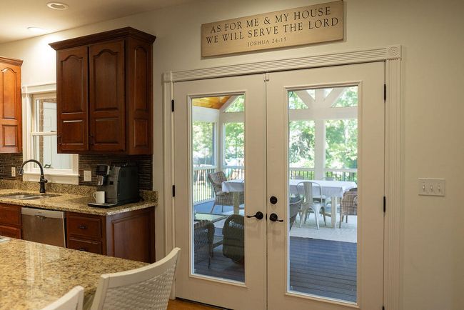 Kitchen French doors leading out to screened-in porch. | Image 26