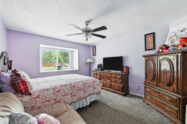 Carpeted bedroom featuring a textured ceiling and a ceiling fan | Image 21