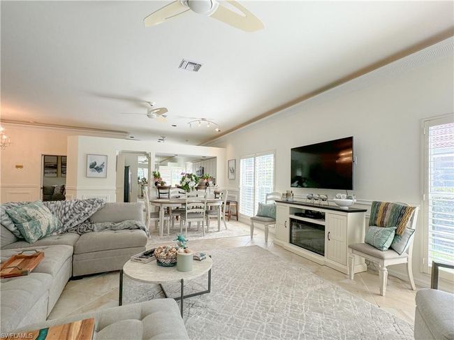Living room with ceiling fan, crown molding, and light tile floors | Image 29