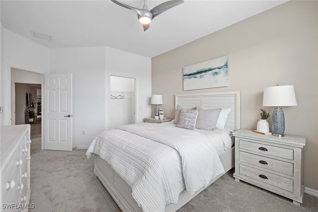Bedroom featuring a closet, baseboards, a spacious closet, a ceiling fan, and light colored carpet | Image 32