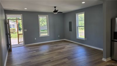 Unfurnished room featuring dark wood-type flooring, ceiling fan, and electric panel | Image 3