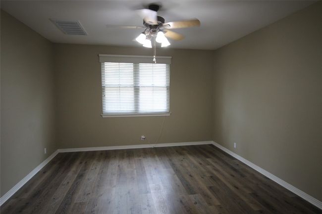 Unfurnished room featuring ceiling fan and dark wood-style floors | Image 18