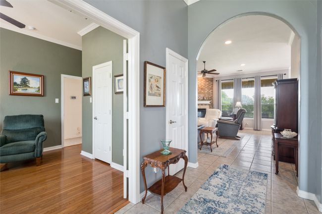 Corridor with arched walkways, ornamental molding, recessed lighting, light wood-style flooring, and a towering ceiling | Image 12