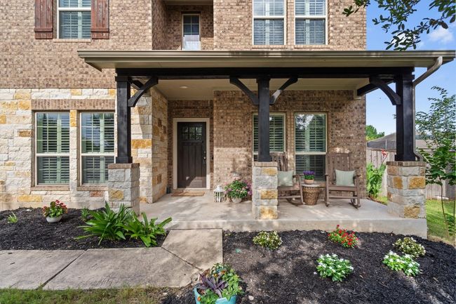 View of exterior entry with covered porch and brick siding | Image 4