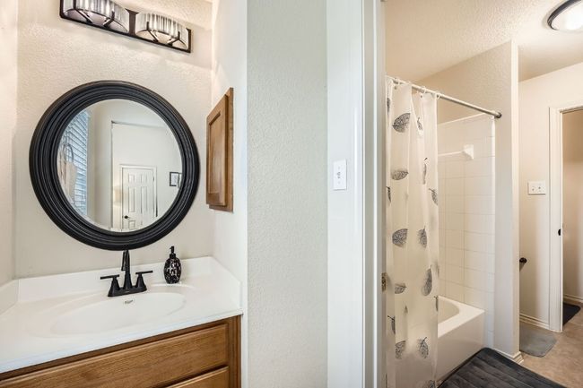 Bathroom with vanity, shower / tub combo with curtain, and a textured wall | Image 23