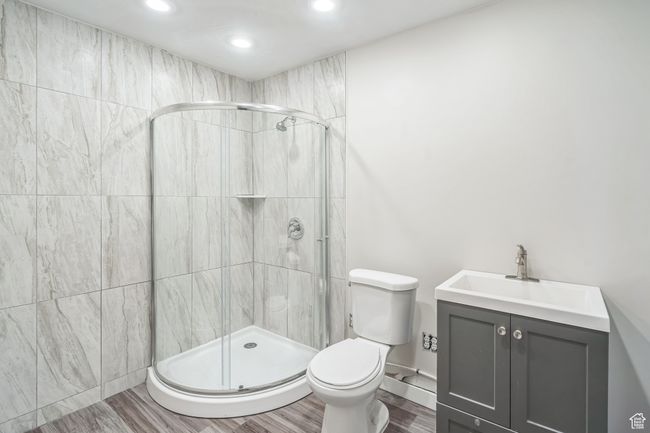 Bathroom with a shower stall, vanity, wood finished floors, and recessed lighting | Image 15