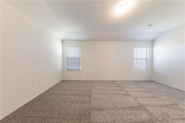 Empty room featuring light colored carpet and vaulted ceiling | Image 8
