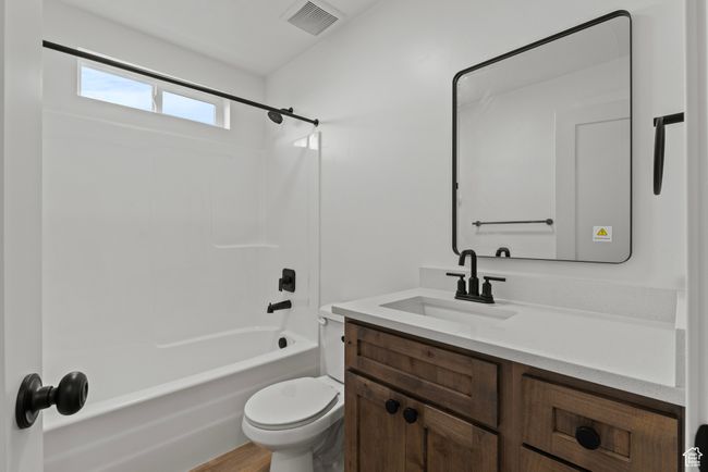 Bathroom featuring vanity, toilet, shower / tub combination, and wood finished floors | Image 16