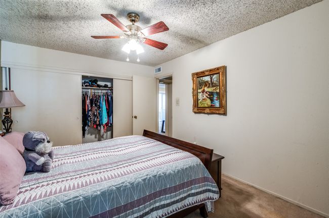 Carpeted bedroom featuring a closet, a textured ceiling, and a ceiling fan | Image 20