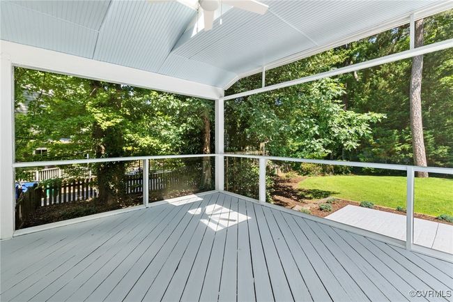 Screened porch with a ceiling fan with light. | Image 34