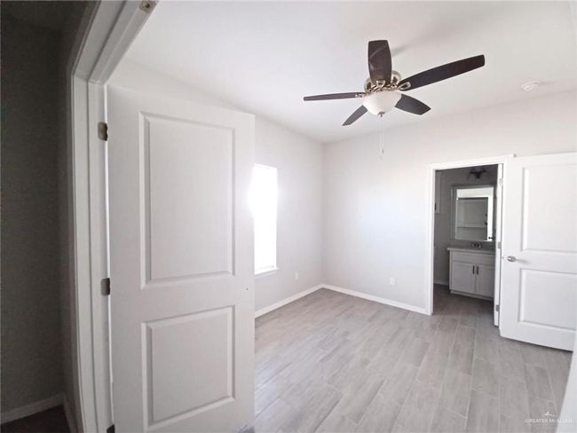 Unfurnished bedroom with light wood-style flooring, baseboards, and a ceiling fan | Image 7