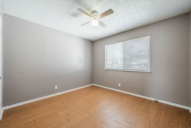 Unfurnished room featuring a ceiling fan, wood finished floors, and a textured ceiling | Image 27