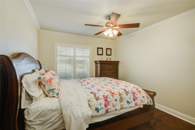 This first secondary bedroomcontinues the home's neutralpalette, featuring crown moldingand oversized windows that fillthe room with natural light. | Image 23