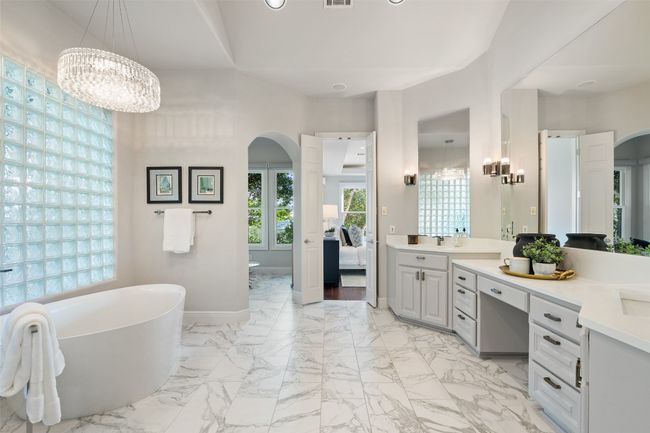 Ensuite bathroom featuring a soaking tub, vanity, a chandelier, baseboards, and recessed lighting | Image 22