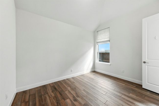Empty room with lofted ceiling and tile floors | Image 28