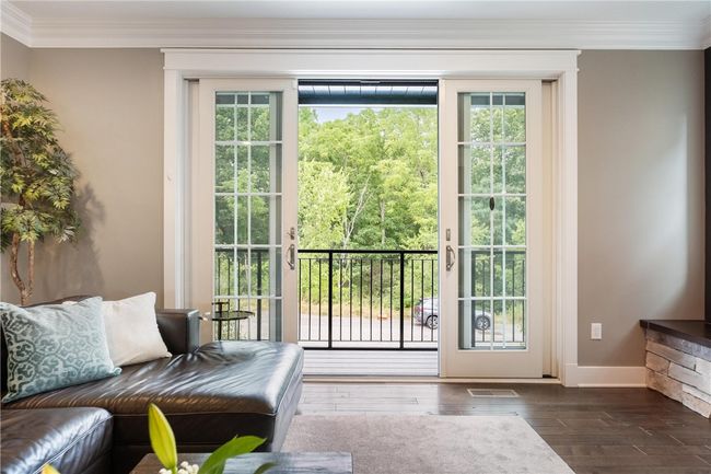 Main floor Living Room has sliding doors to a balcony, offering plenty of light. | Image 5