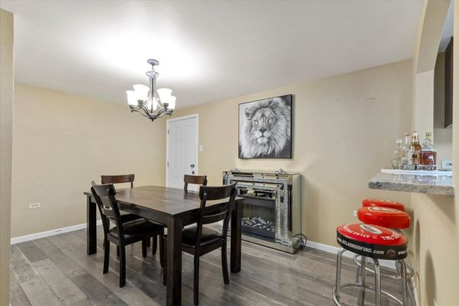 Dining room featuring a notable chandelier, baseboards, and wood finished floors | Image 12