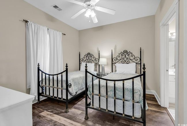 Bedroom featuring wood finished floors, ceiling fan, baseboards, and visible vents | Image 12