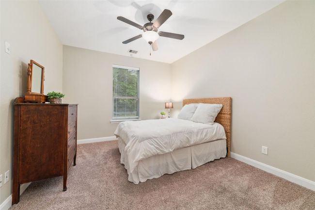 Just past the laundry room is a hallway leading to the third secondary bedroom and full bathroom at the back of the home. | Image 20