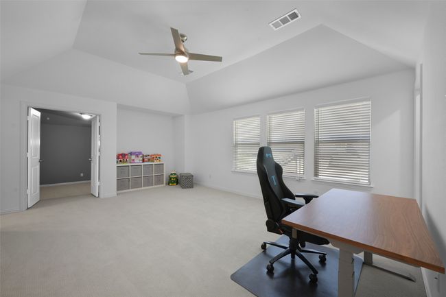 Game room/ second living space/ study area with vaulted ceiling, and ceiling fan showing the double doors entry to the Media. | Image 26