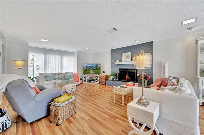 This oversized family room provides plenty of space for entertaining, with large windows that flood the room with natural light and a cozy fireplace as the focal point. | Image 6