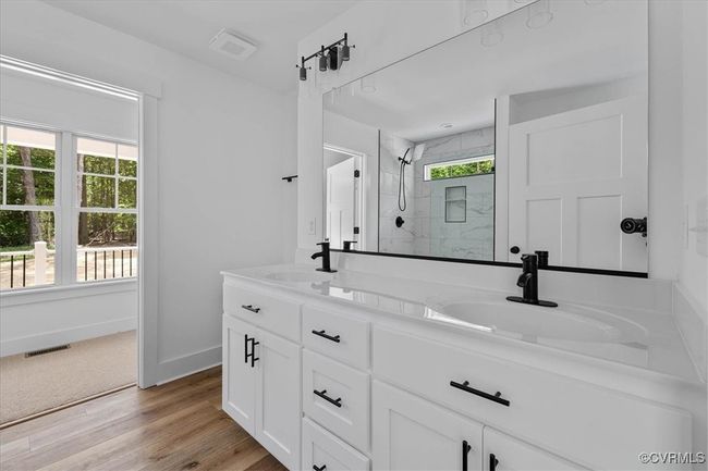 Full bathroom featuring visible vents, baseboards, a shower stall, and a sink | Image 19
