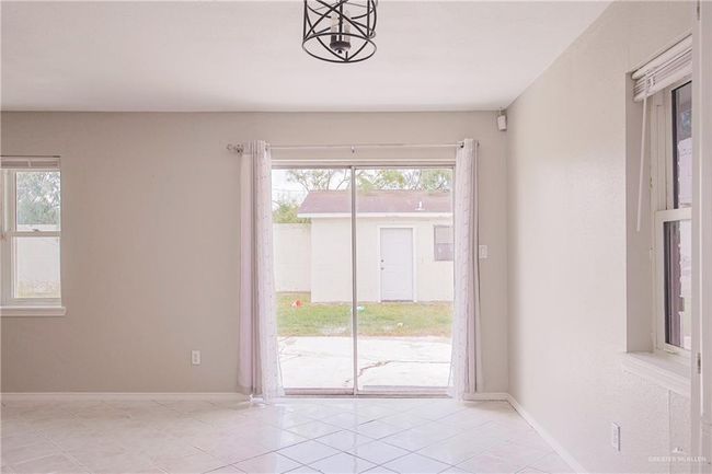 Unfurnished room with baseboards, light tile patterned floors, and a wealth of natural light | Image 13
