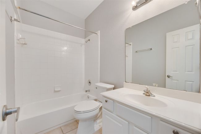 Bathroom featuring bathtub / shower combination, vanity, toilet, and tile patterned floors | Image 14