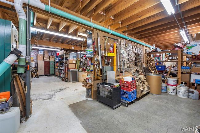 Unfinished basement with a workshop area | Image 45