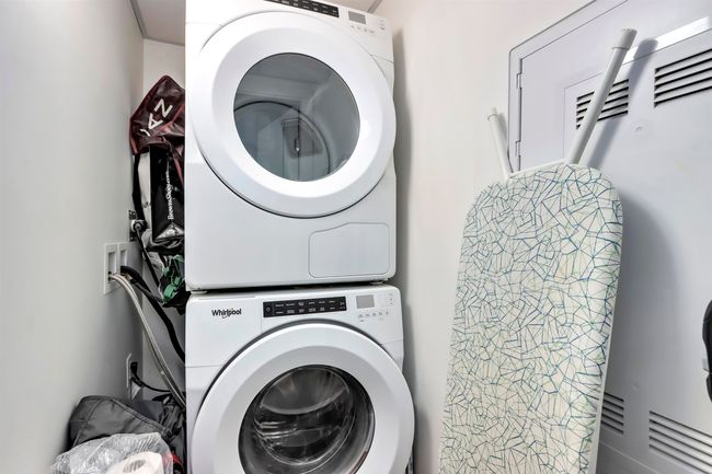 Laundry area with stacked washer and clothes dryer and laundry area | Image 14