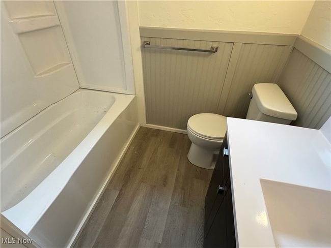 Full bathroom featuring wood-type flooring, shower / washtub combination, vanity, and toilet | Image 12