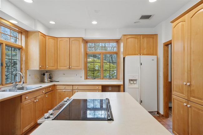 Kitchen with recessed lighting, light countertops, visible vents, a sink, and white refrigerator with ice dispenser | Image 14