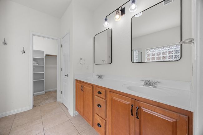 Primary En-Suite Bathroom featuring double vanity, tile patterned floors, and a walk in closet | Image 19