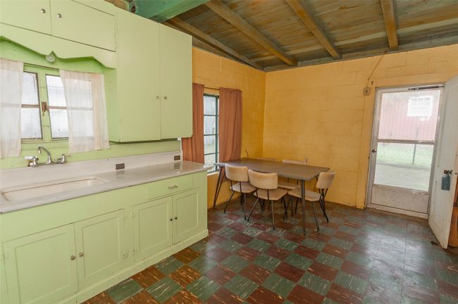 Kitchen with wooden ceiling, green cabinets, a sink, light countertops, and vaulted ceiling with beams | Image 24