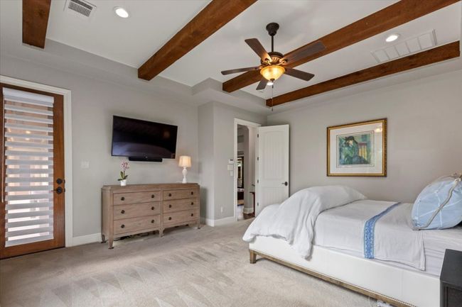 Carpeted bedroom featuring baseboards, beamed ceiling, and visible vents | Image 16