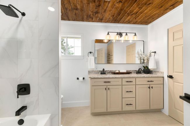 Luxurious primary bedroom ensuite featuring a stunning wooden ceiling, elegant double vanity, custom soft-close cabinetry | Image 22