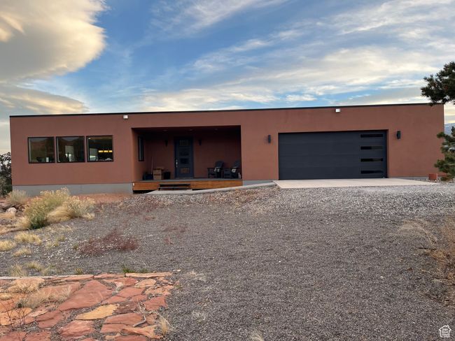 View of front facade with driveway, stucco siding, and an attached garage | Image 47