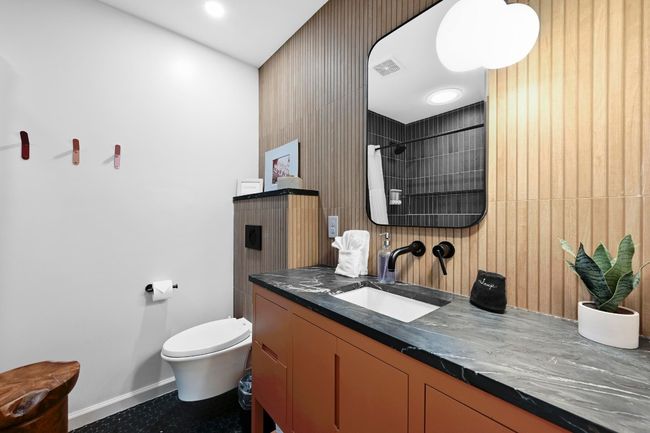 The full guest bathroom is also completely remodeled with soapstone countertops, wall-hung toilet, and custom vanity. | Image 32