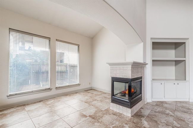 Additional den, living space overlooks the side yard. Notice the built in with storage and beautiful tile floor. | Image 24