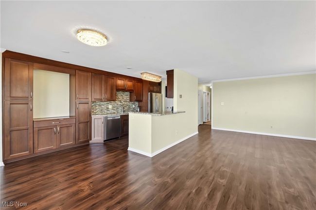 Kitchen with baseboards, dark wood finished floors, open floor plan, decorative backsplash, and appliances with stainless steel finishes | Image 9