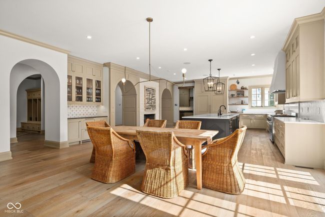 dining space with arched walkways, light wood finished floors, ornamental molding, and recessed lighting | Image 18
