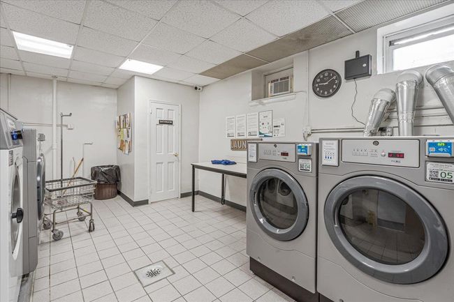 Shared laundry with washing machine and dryer and light tile patterned floors | Image 15