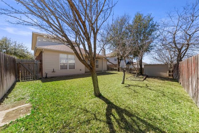 View of yard featuring an outdoor structure, a gate, a storage unit, and a fenced backyard | Image 21